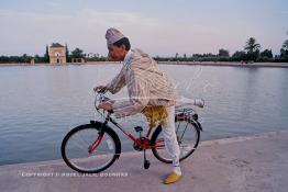 Image du Maroc Professionnelle de  Un Marrakchi vêtu d'une tenue typiquement des habitant de Marrakech reprend son vélo pour rentrer après une promenade à la Ménara, Mercredi 21 Août 1997. (Photo / Abdeljalil Bounhar) 